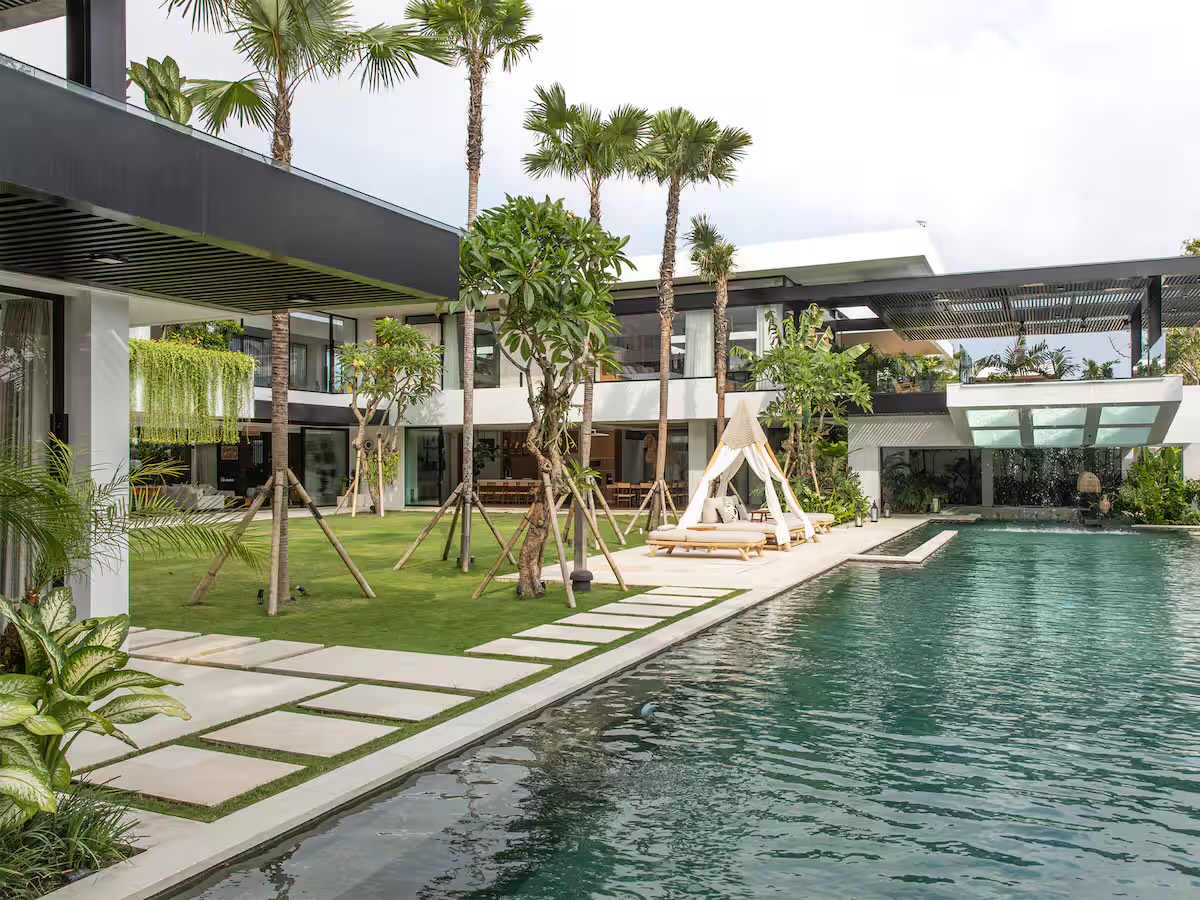 The villa's lawn, palms and pool seen from the walkway