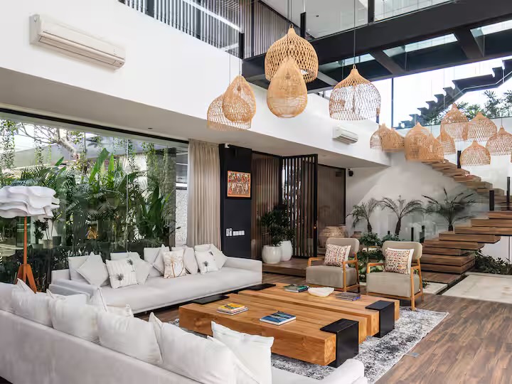 White sofas and rattan pendant lights in the double-height living room