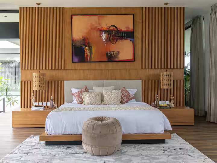 A guest bedroom with a timber-slatted wall and abstract artwork