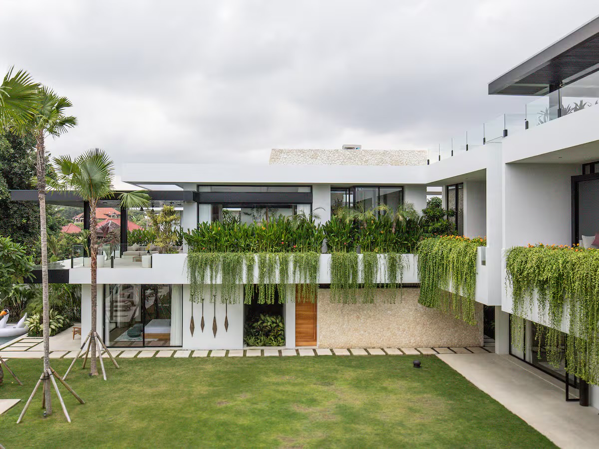The villa exterior with hanging greenery over the lawn